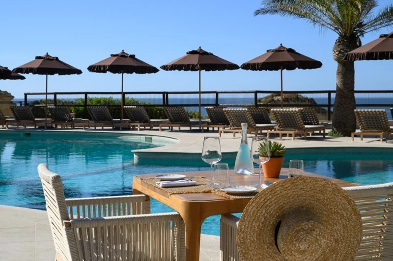 Pool-side table with straw hat at A Costa Restaurant