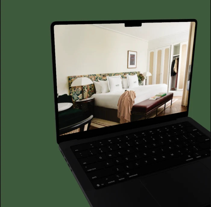 Laptop showing the hotel website on green background, BLESS Madrid