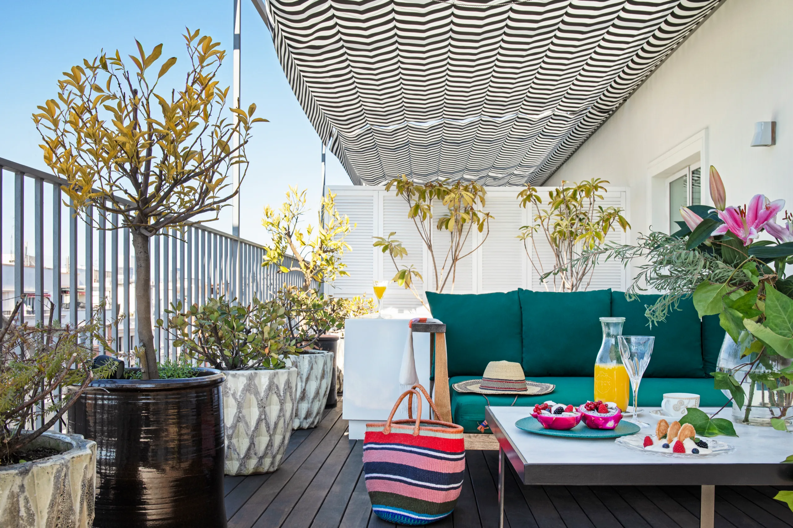 Terrace with striped awning and green sofa, BLESS Madrid