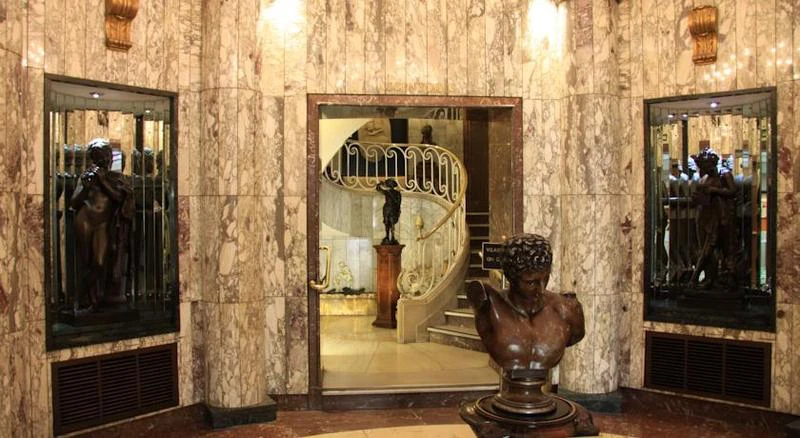 Marble lobby with a bronze bust and a spiral staircase, BLESS Madrid