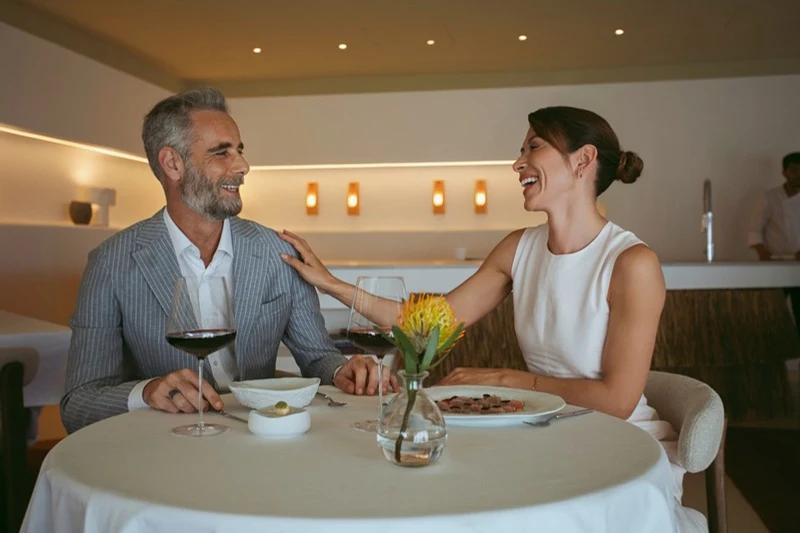 Couple laughing at table at Coral, Edén do Mar