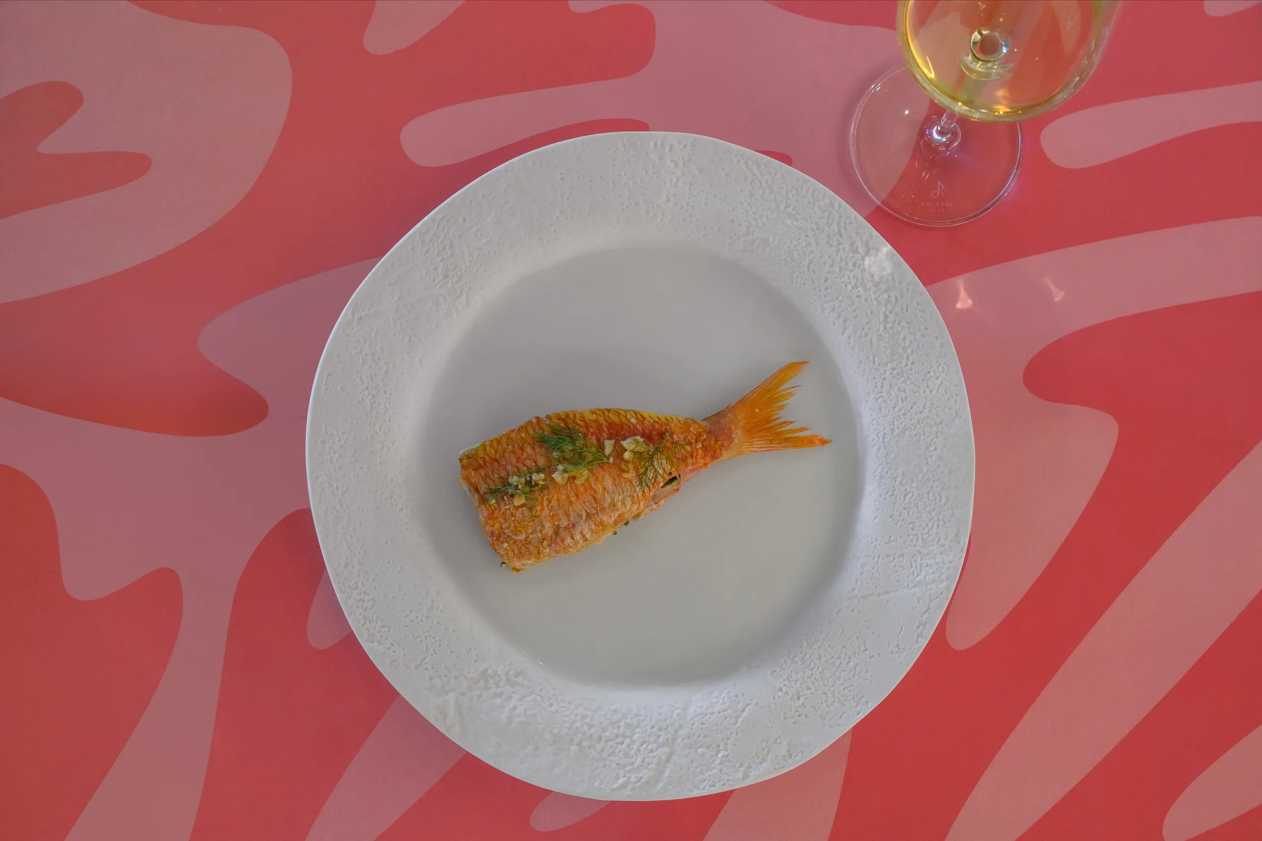 Fish on pink patterned plate at Coral, Edén do Mar