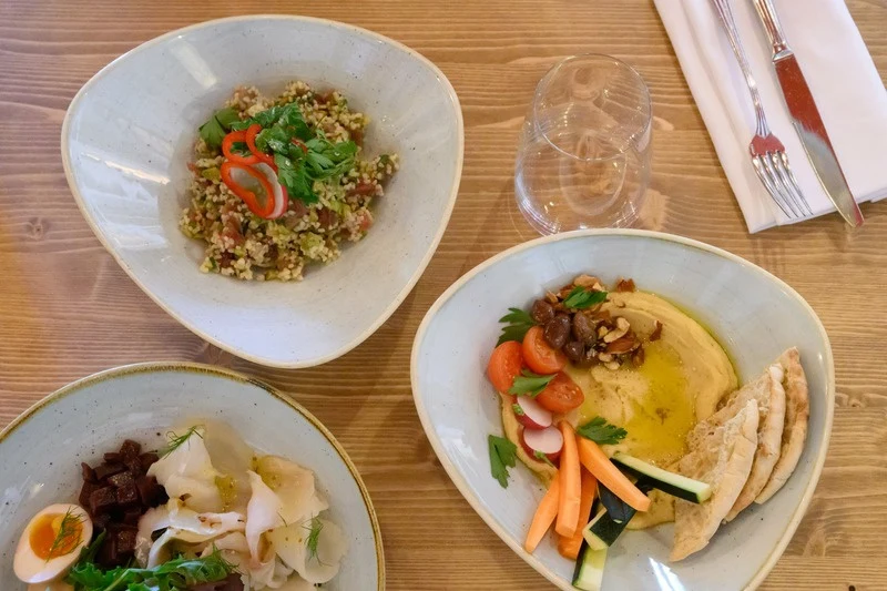Plates of food on wooden table at Vento Restaurant